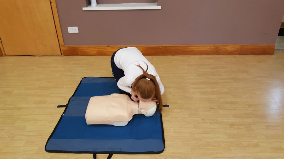 Trainee illustrates how to give rescue breaths to an unconscious child that is not breathing